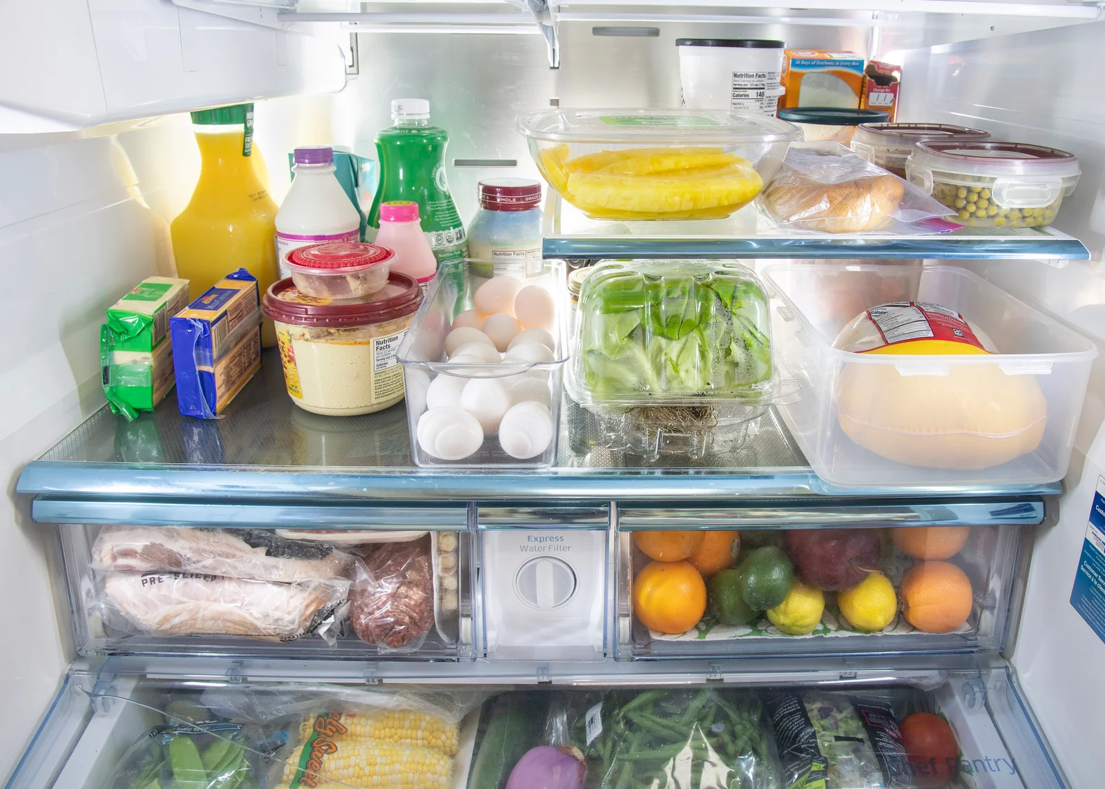 Open refrigerator shelves filled with food and produce